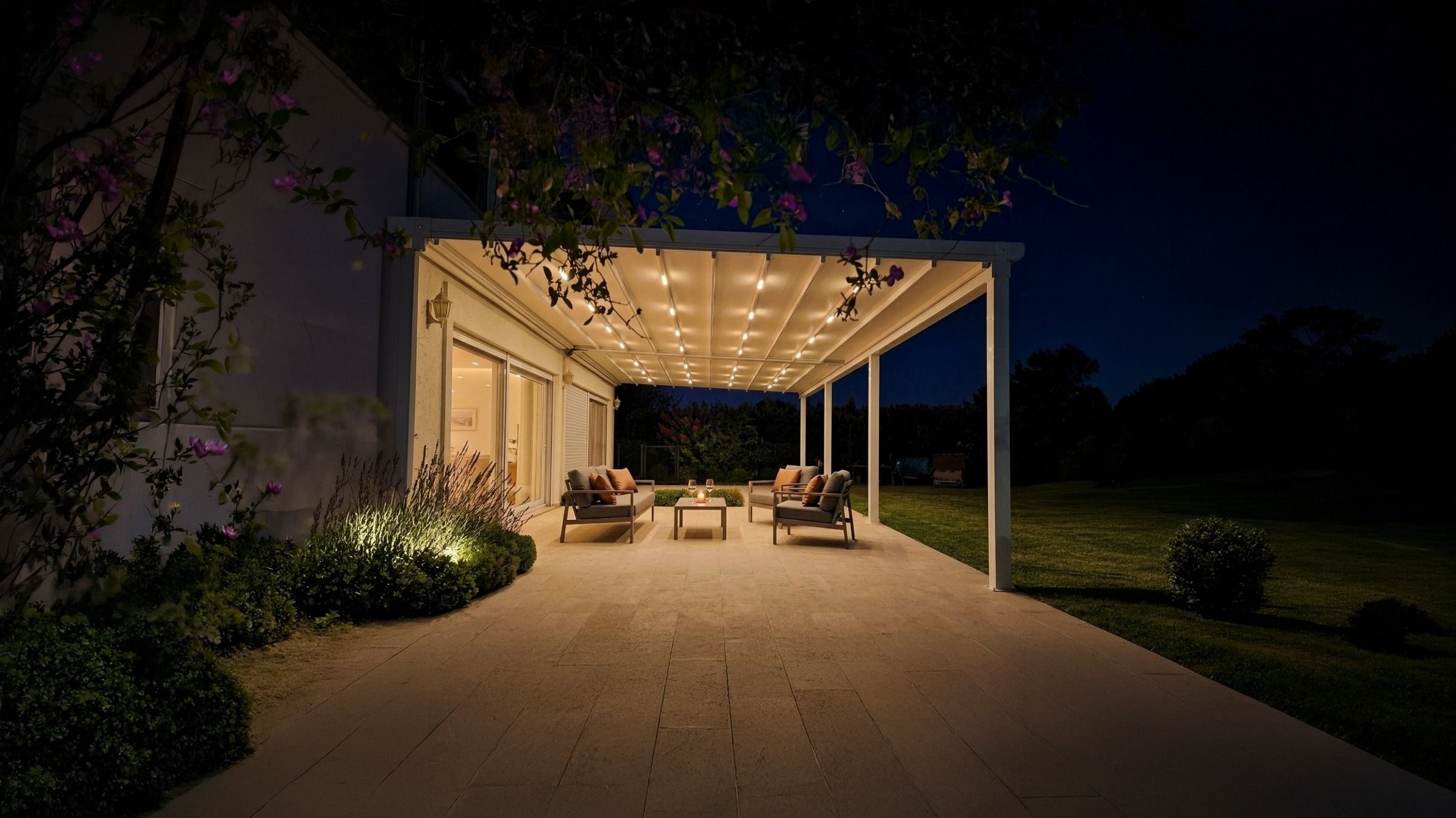 Gece ışıkları yanan otomatik pergola tentenin altında bahçe oturma grubu